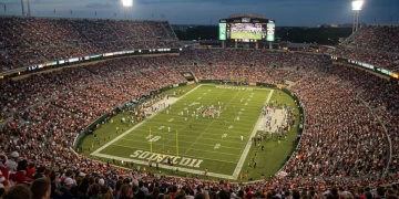 College Football Bowl Game Payouts 2025: Financial Implications & Revenue Aerial view of a college football bowl game stadium at night, packed with fans.