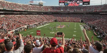 College football stadium with digital overlays of NIL deals and athletes, representing modern endorsement strategies.