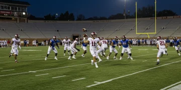 College football offense in action, spread formation, quarterback passing