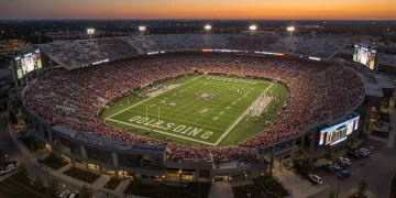 Modern college football stadium with updated facilities, vibrant fan zones, and new seating under evening lights.