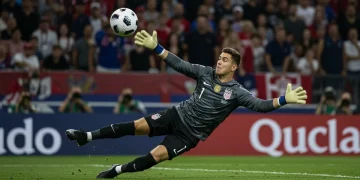 US goalkeeper making a diving save in a professional soccer match