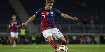 Elite US Soccer Forwards: 3 Key Performance Metrics for 2026 US soccer forward strikes ball towards goal during an intense match.